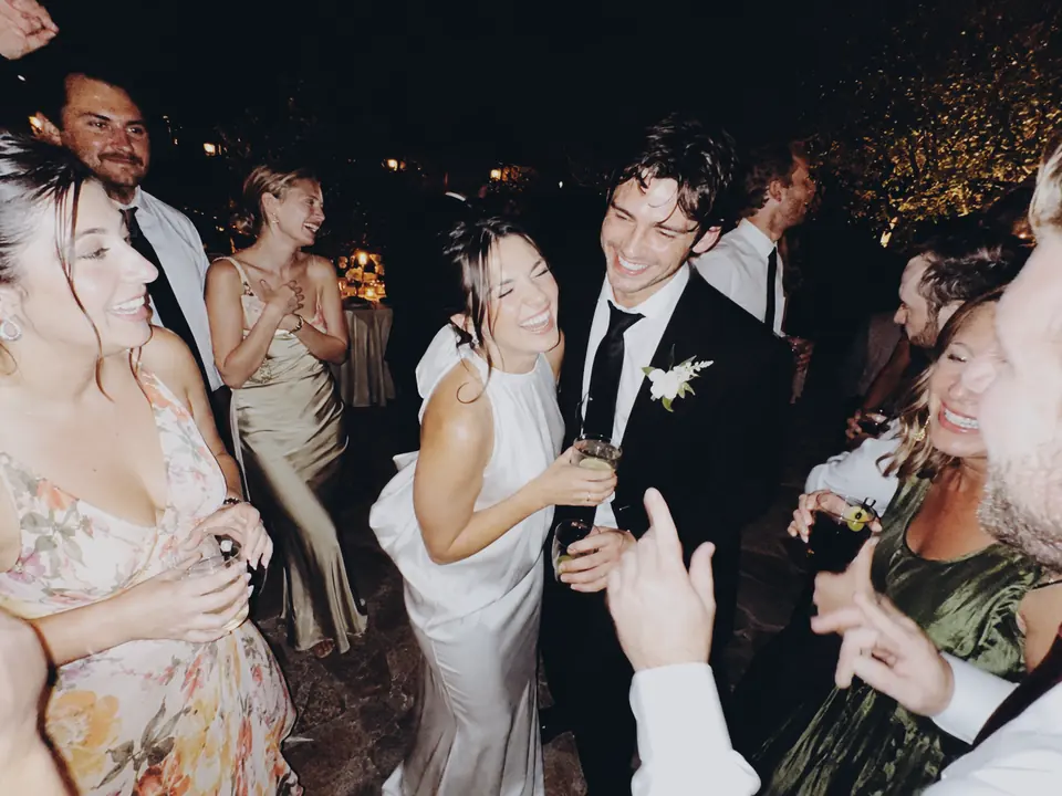 Friends celebrating together at an evening wedding reception